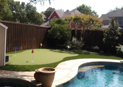 putting green near pool with fake grass